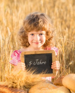 Happy child with bread in field
